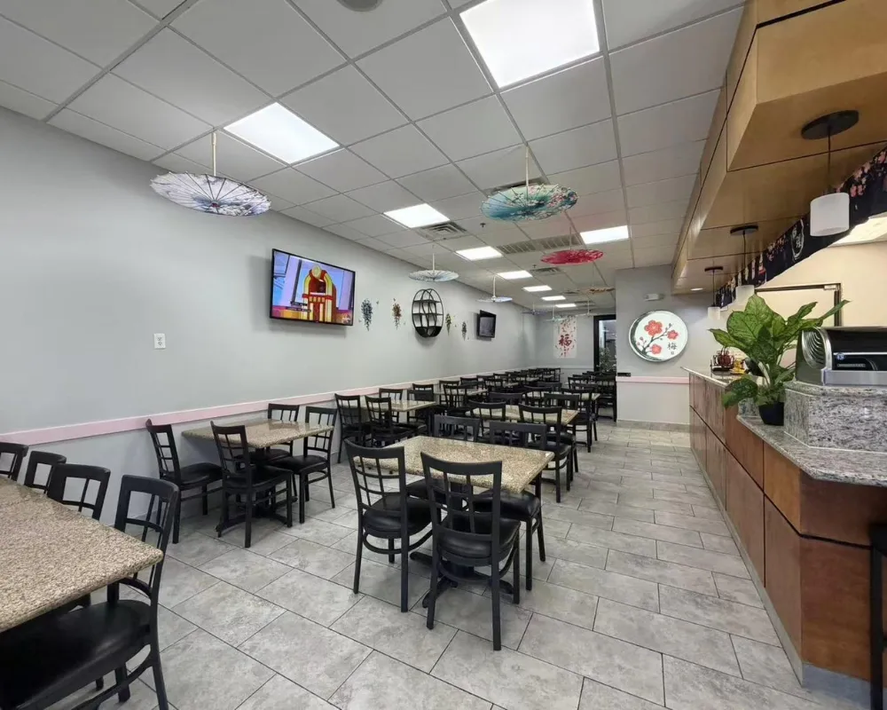 Wide‑angle view of restaurant dining space with wall‑mounted TV at Mei Garden Asian Cuisine, a Asian Restaurant in Sugar Land